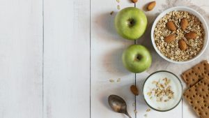 Glass of yoghurt, cereal and apples